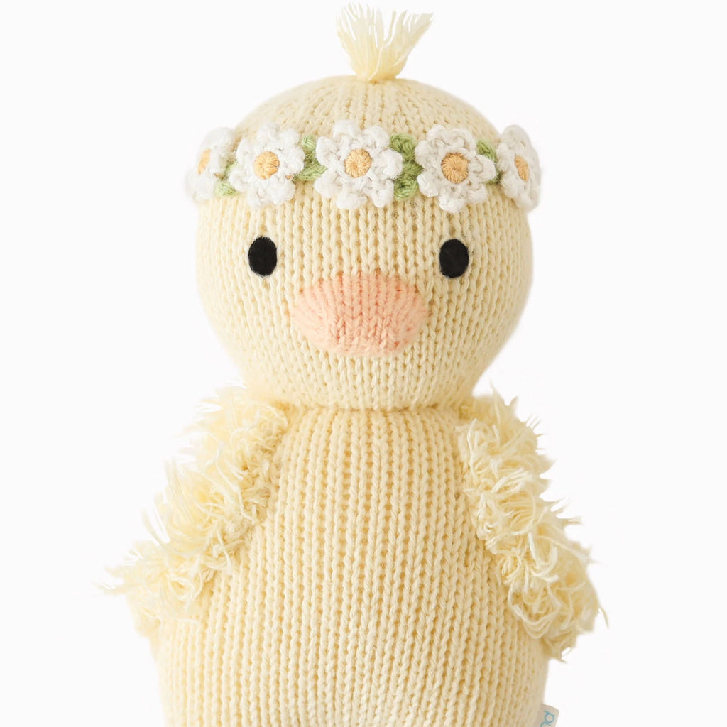 yellow duck stuffy with white flower head band flat lay