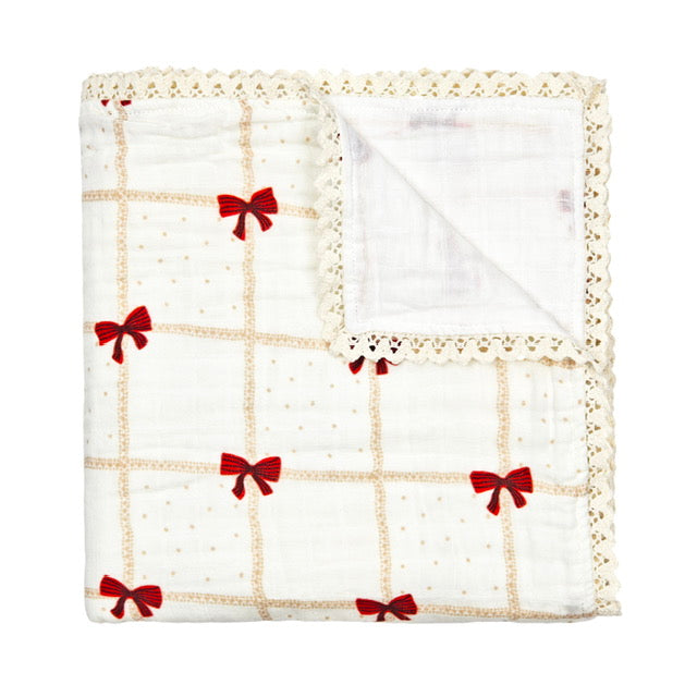 Beige Blanket with red bows and lace flat lay.