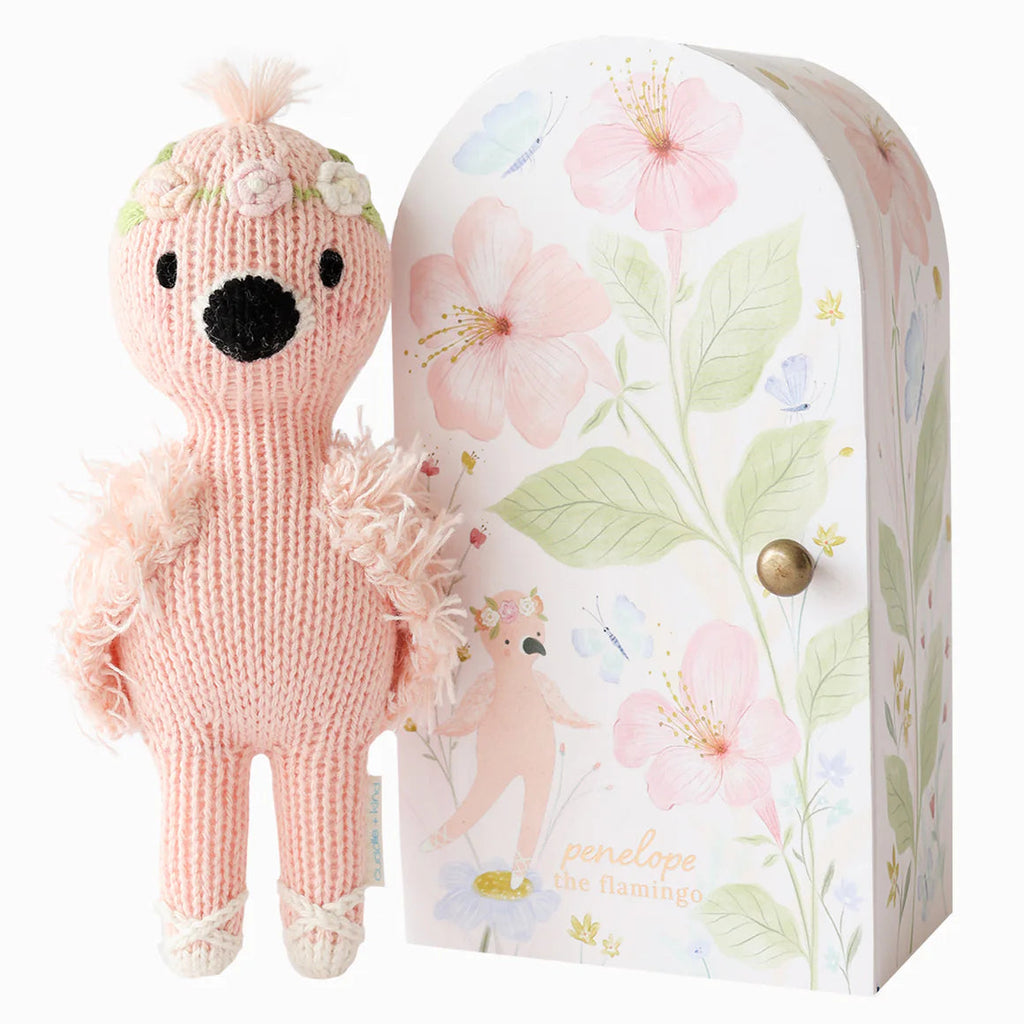 flamingo stuffy standing beside floral box