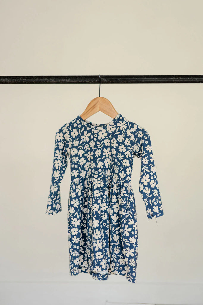 Blue and white floral dress hanging on a hanger.