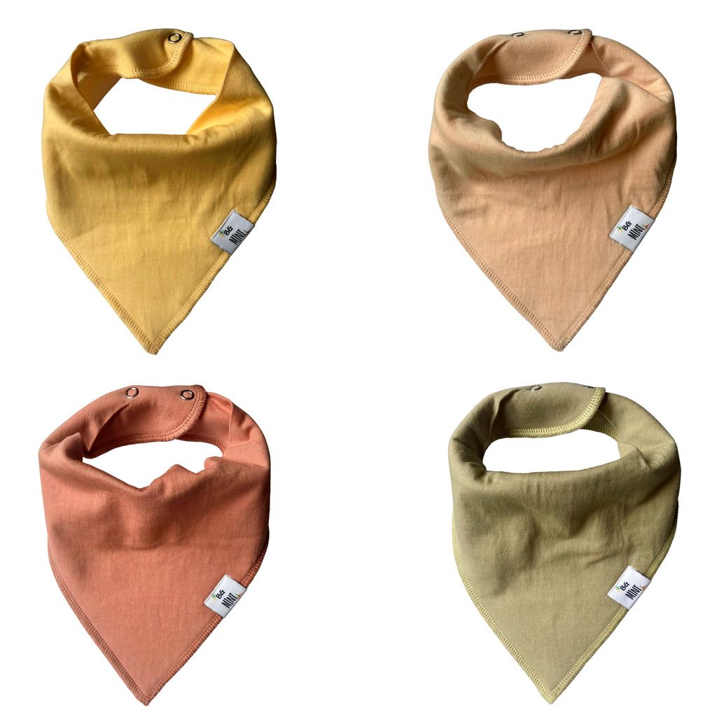 Set of 4 bibs. Yellow, beige, coral, and green flat lay