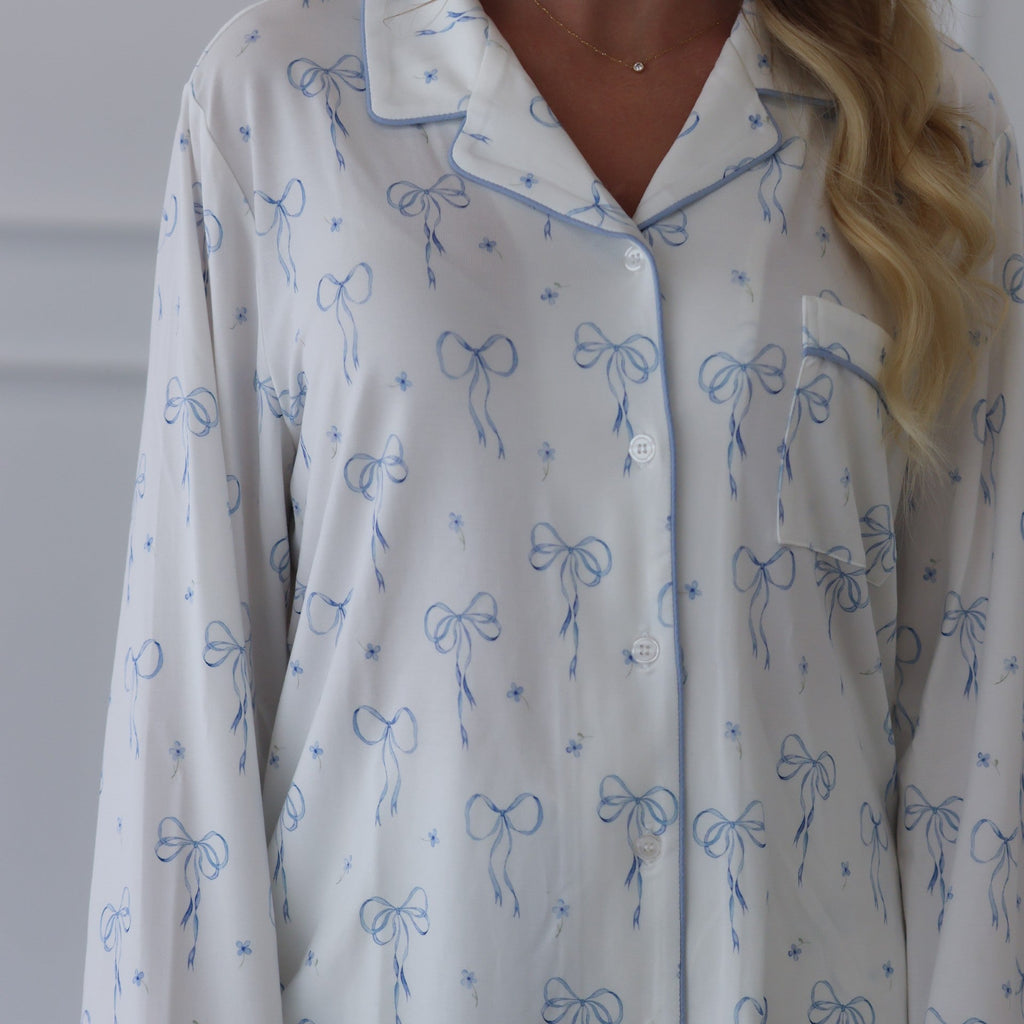 White shirt with blue bow pattern worn by a person against a neutral background